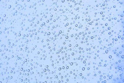 Full frame shot of raindrops on blue water