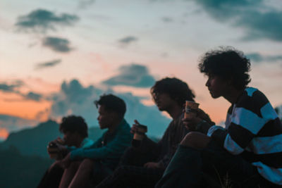 Group of people at restaurant against sky during sunset