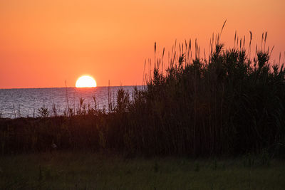 Scenic view of sea against romantic sky at sunset