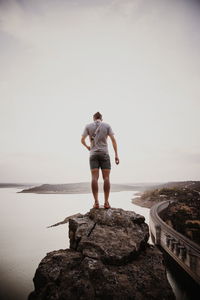 Rear view of man looking at sea against sky