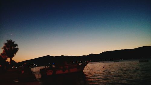 Boats in sea at sunset