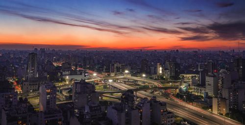 High angle view of illuminated buildings against sky during sunset