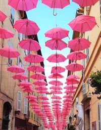 Low angle view of multi colored umbrellas hanging outside building