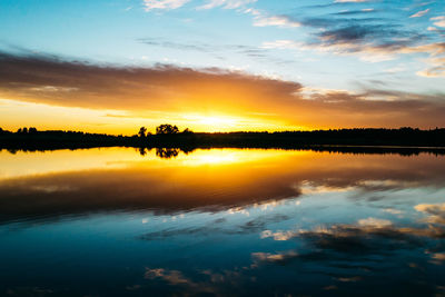 Summer sunset on the lake with a mirror reflection of the sky