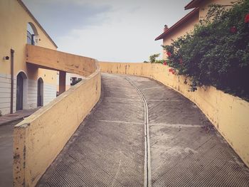 Empty road amidst buildings against sky