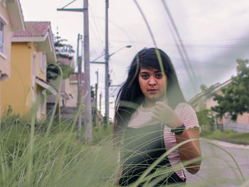 Portrait of young woman standing on field