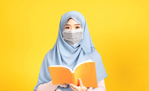 Portrait of person wearing hat against yellow background