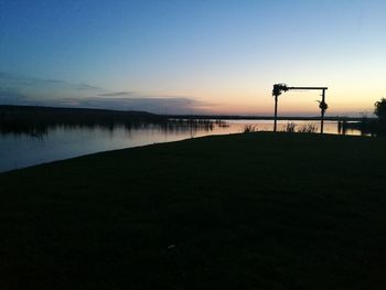 Scenic view of lake against clear sky at sunset