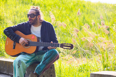 Man playing guitar on grass