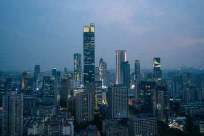 Illuminated buildings in city against sky at night