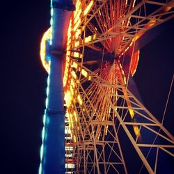 Low angle view of illuminated ferris wheel at night