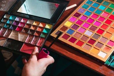 Woman in front of her dressing table holding her worn out eyeshadow palette