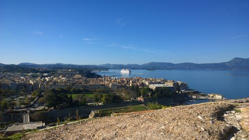 Scenic view of sea by buildings against blue sky