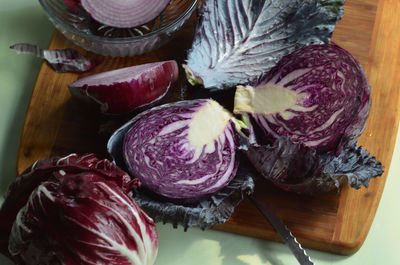Radicchio, knife, cut red cabbage red onion, on bamboo cutting board on light green surface