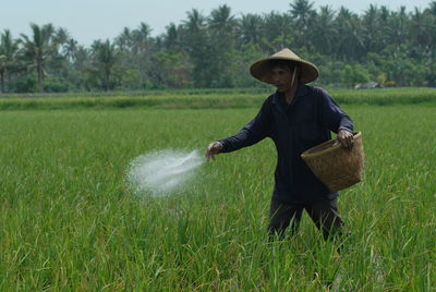 Rear view of woman standing on field