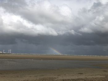 Scenic view of sea against storm clouds