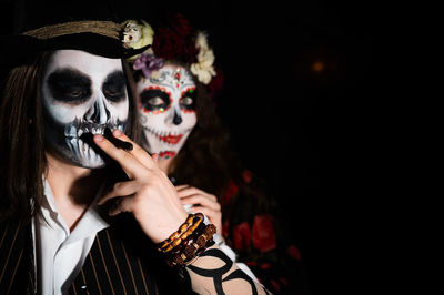 Portrait of young woman holding mask during halloween