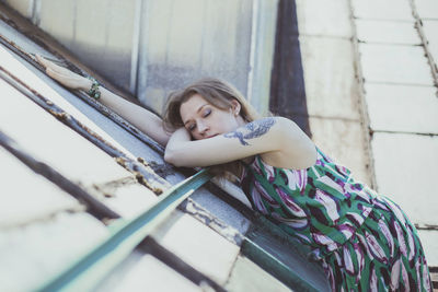 Woman with closed eyes lying over shabby roof scenic photography