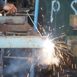 Cropped hand welding metal in workshop