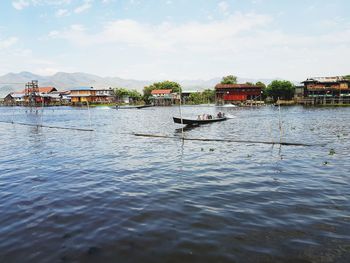 Long tail boat in sea against sky