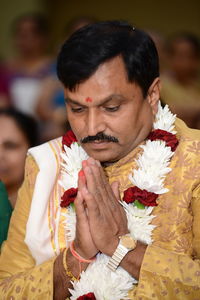 Close-up of bridegroom praying at wedding 