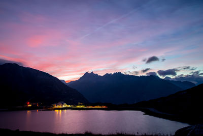 Scenic view of lake by mountains against romantic sky