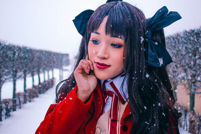 Woman looking down while standing in winter