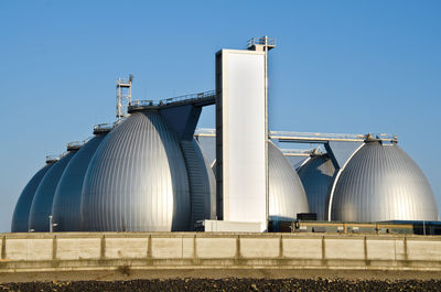 Low angle view of factory against clear blue sky