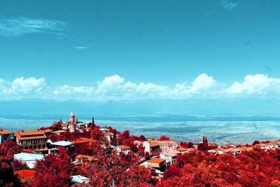 High angle view of townscape by sea against sky