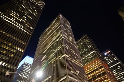 Low angle view of illuminated buildings against sky at night