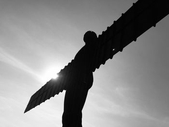 Low angle view of silhouette sculpture against sky