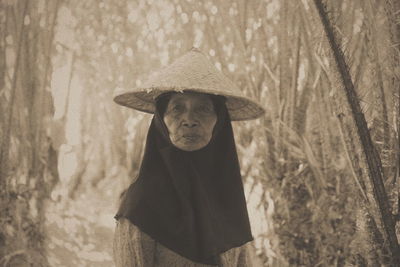 Portrait of senior woman wearing asian style conical hat