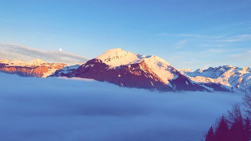 Scenic view of snowcapped mountains against blue sky