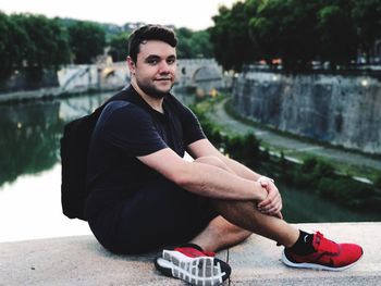 Young man sitting on wall