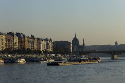 Boats in river with buildings in background