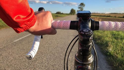 Midsection of woman with bicycle on road