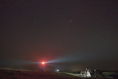 Illuminated landscape against sky at night