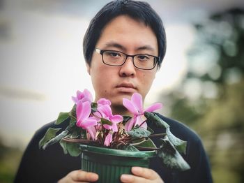 Portrait of woman holding pink flower