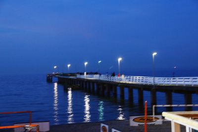 View of illuminated pier at night