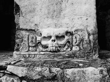 Close-up of buddha statue against stone wall