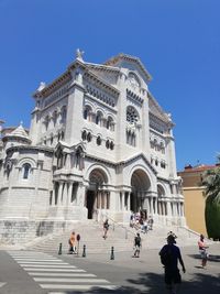 Group of people in front of building against blue sky