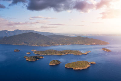 Scenic view of sea and mountains against sky