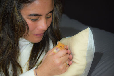 Close-up portrait of beautiful woman holding rodent