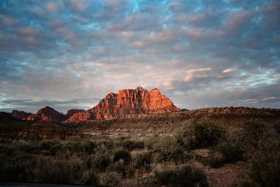 Rock formations on landscape against cloudy sky