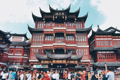 Group of people in traditional building against sky