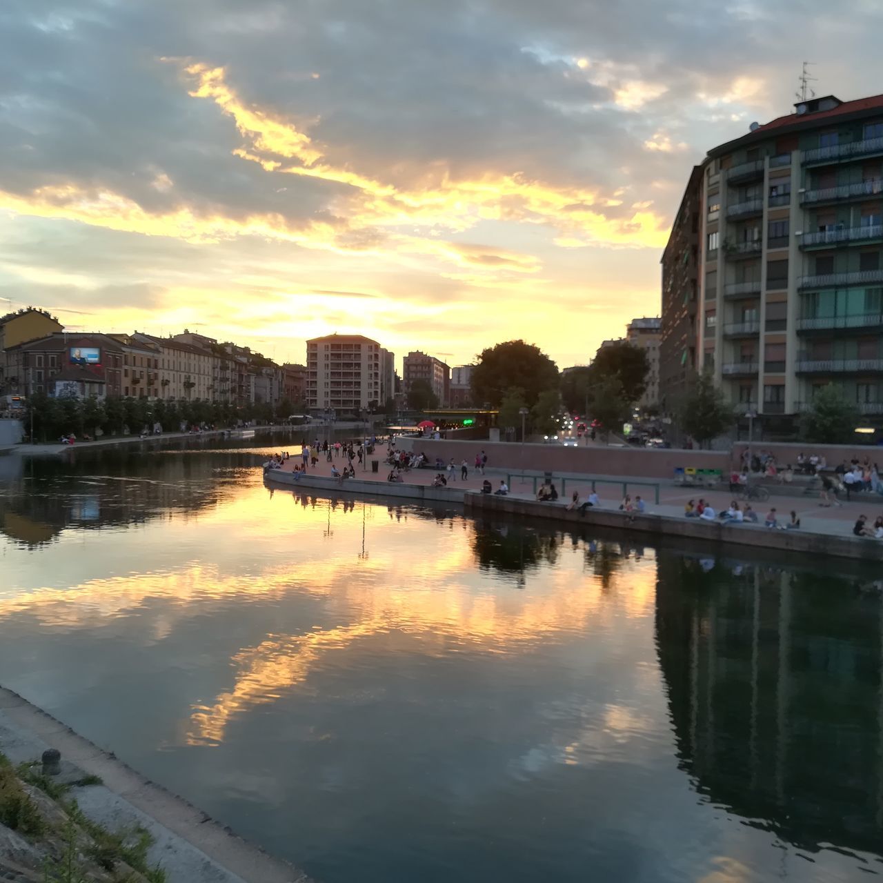 architecture, cloud - sky, sunset, sky, built structure, building exterior, water, reflection, city, transportation, nature, waterfront, orange color, building, no people, river, outdoors, mode of transportation, bridge, cityscape