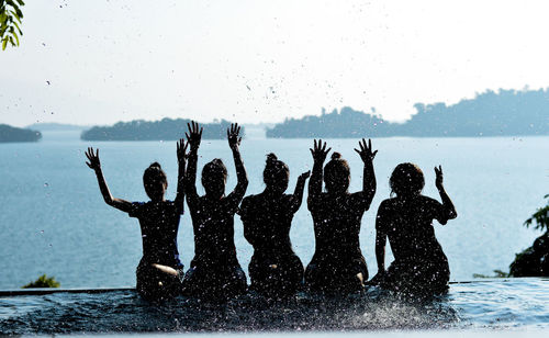 People enjoying in swimming pool against sky