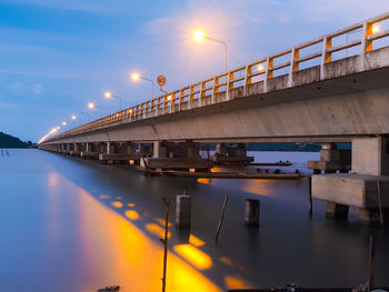 Bridge over river against sky during sunset