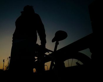 Low angle view of silhouette man standing against clear sky