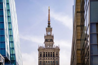 Low angle view of clock tower in city against sky